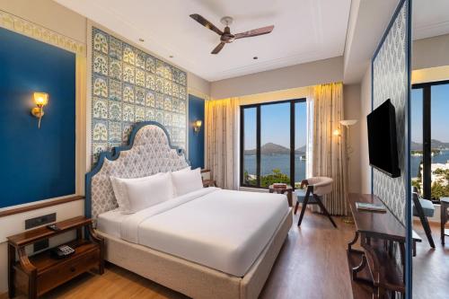 a bedroom with a king sized bed and a tv at Acacia Somgarh Udaipur in Udaipur
