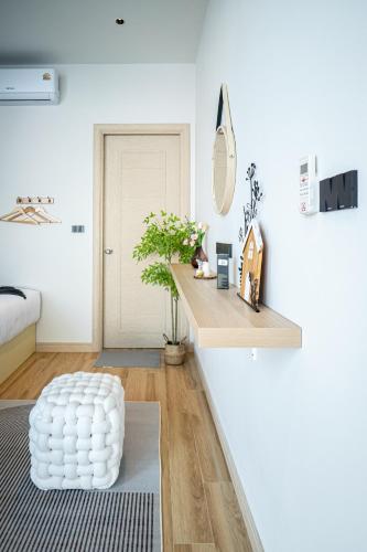 a living room with white walls and a white ottoman at Gam-Hom Poolvilla ชะอำ in Ban Hua Phrong