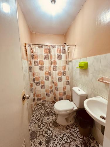 a bathroom with a toilet and a sink at Bacolod Transient Home in Bacolod