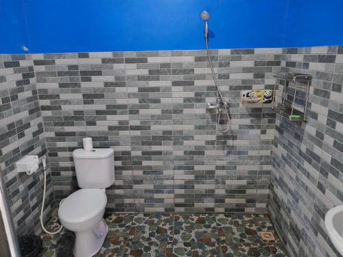 a bathroom with a toilet and a shower at Giri Homestay in Amed
