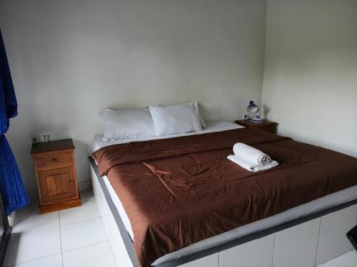 a bedroom with a bed with two towels on it at Giri Homestay in Amed
