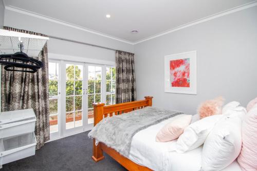 a bedroom with a bed and a window at Bolton Street Cottage in Lower Hutt