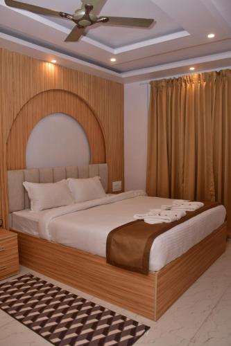 a bedroom with a large bed with a ceiling fan at Hotel Devi Palace in Rājgīr