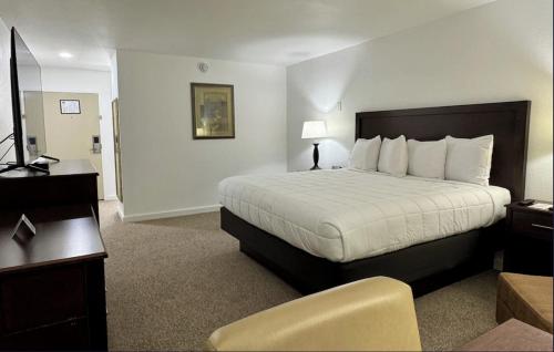a hotel room with a bed and a chair at Heritage Hotel of Quincy in Quincy