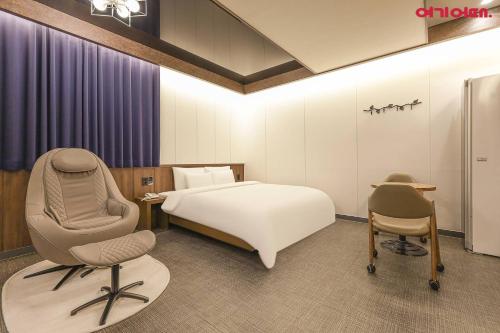 a hotel room with a bed and a chair at Jinju KAI Tourist Hotel in Jinju