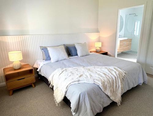 a bedroom with a large bed with two lamps and a mirror at Spring Haven in Wagga Wagga