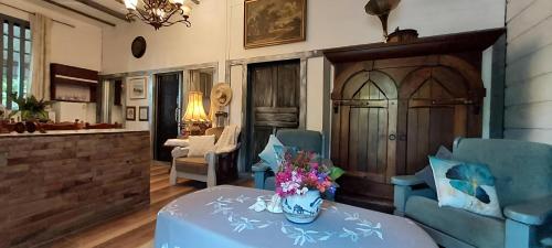 a living room with a table with a vase of flowers on it at Village Homestay in Udon Thani