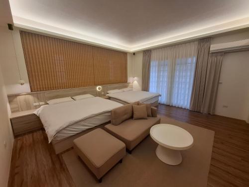 a large bedroom with two beds and a couch at Lan Cheng Su in Yuanshan