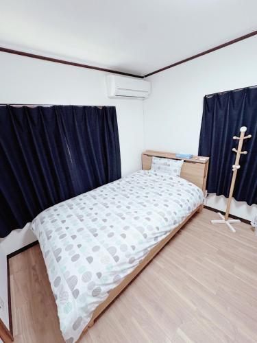 a bed in a room with a cross on the floor at 谷町線歩く5分 梅田駅まで8分 Wi-Fiあり 今年リフォーム済み in Osaka