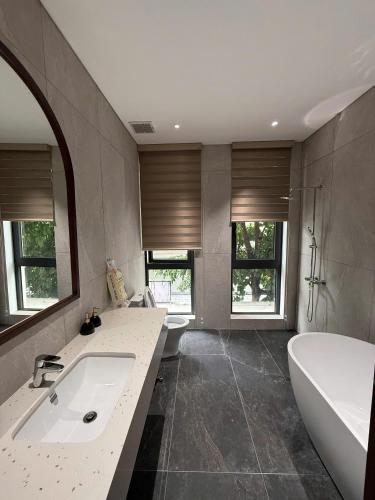 a bathroom with a tub and a sink and a bath tub at MoonLight Homestay in Hòa Bình