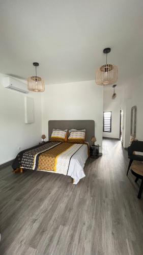 a bedroom with a bed and two chandeliers at ATÈRLA - Appartement de charme et SPA privée in La Possession