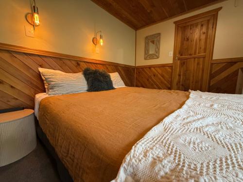 a dog sitting on a bed in a bedroom at Te Anau Lakefront Backpackers in Te Anau