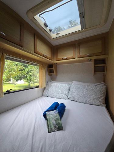 a bed in a small room with a window at TheBoxCaravan in Ban Pak Ram
