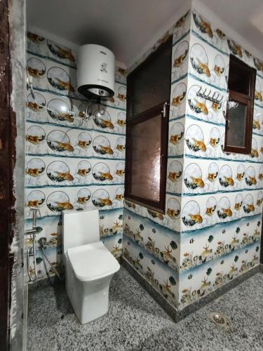a bathroom with a toilet and a wall of plates at RSR event service in Faridabad