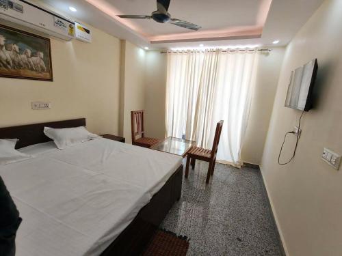 a bedroom with a bed and a table and a ceiling fan at RSR event service in Faridabad