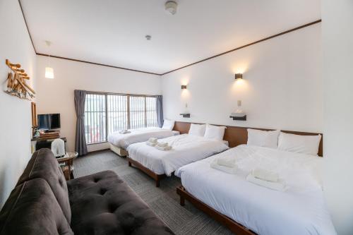a hotel room with two beds and a couch at 開港庵 in Hakodate