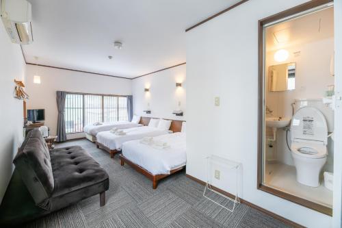 a hotel room with two beds and a toilet at 開港庵 in Hakodate