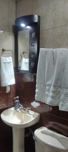 a bathroom with a sink and a toilet and towels at Casa tabachin in Arandas