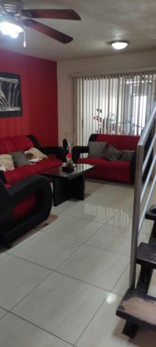a living room with red walls and a red couch at Casa tabachin in Arandas