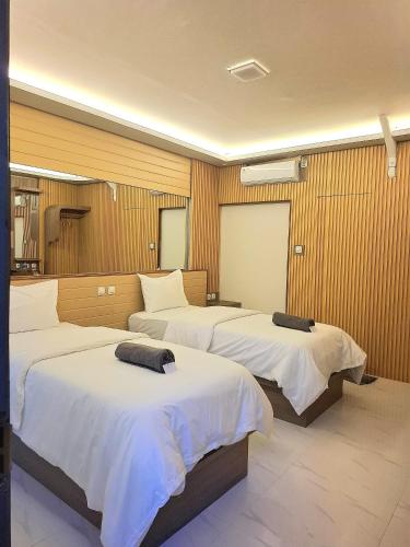 a bedroom with three beds in a room at 7 Day Inn in Gili Trawangan