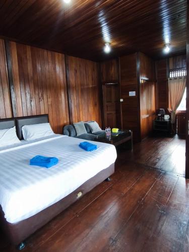 a bedroom with a large bed and a couch at D Royale Tapos Resort Bogor in Tapos