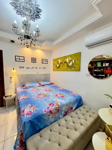 a bedroom with a bed and a chandelier at 4 quartos Folia de Olinda in Olinda
