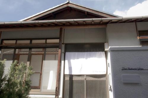 a white house with a gate and a fence at The Nature Uno 2026年リノベーション 直島好アクセス 古民家一棟貸切 最大4名2ldk平家 クイーンベッド2台 in Tamano