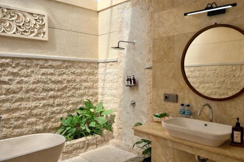 a bathroom with a sink and a mirror at Emstaliese & Palmarosa Villas Seminyak in Legian