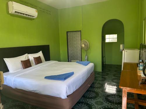 a bedroom with a large bed in a green room at ABC Bungalow in Ban Tai