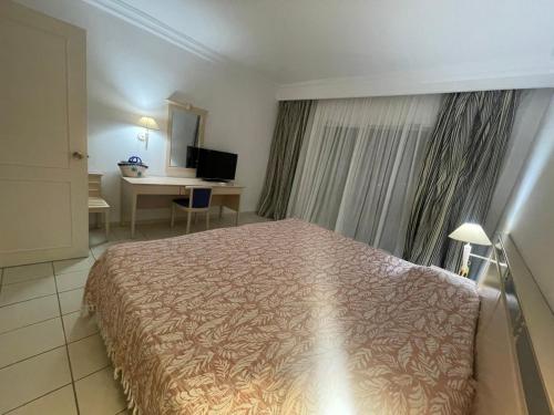 a hotel room with a bed and a desk at Yasmina Hotel Appartment in Yasmine