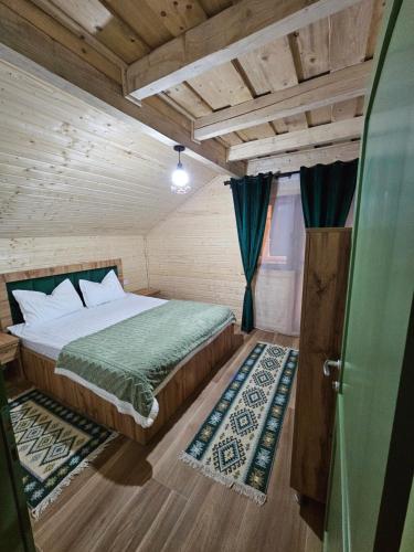 a bedroom with a bed in a wooden room at Casa din fagi in Munună