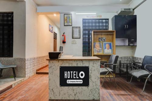 a hotel room with a reception counter and chairs at Hotel O George Town in Colonelganj