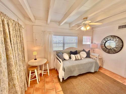 a bedroom with a bed and a table and a window at Baked Beach Bungalow in St. George Island