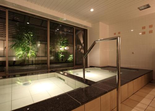 a bathroom with a bath tub in a room at Toyooka Green Hotel Morris in Toyooka