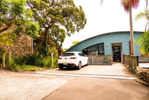 a white car parked in front of a house at Copacabana Fab & Funky in Copacabana