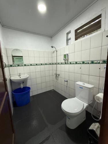 a bathroom with a toilet and a sink at Romlan Guesthouse in Tuktuk Siadong