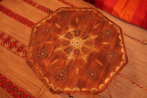 a wooden table sitting on top of a rug at Kasbah Valentine in Aït Ben Haddou