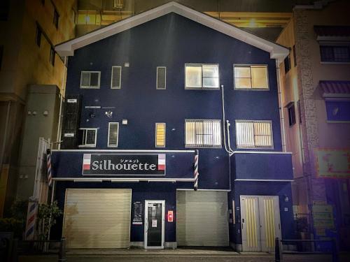a blue building with a sign for a store at ritomaru rooms hakata hakozaki in Fukuoka