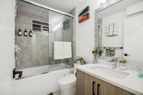a bathroom with a sink and a toilet and a shower at NEST- Modern 2BR Basement Retreat in South Surrey in Surrey