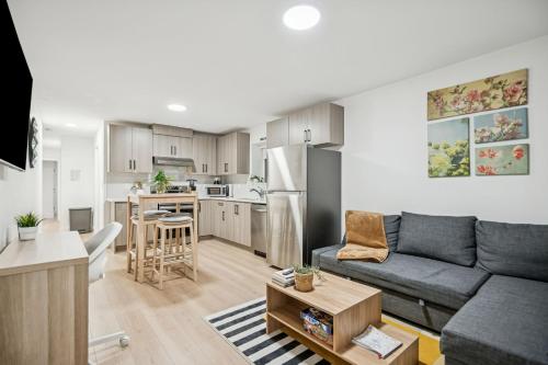 a living room with a couch and a kitchen at NEST- Modern 2BR Basement Retreat in South Surrey in Surrey