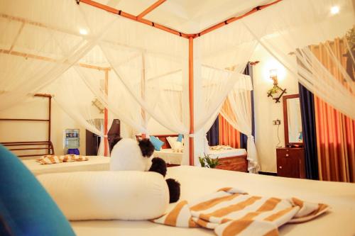 a bedroom with two beds with mosquito nets at Ruwan Jungle Homestay in Mirissa