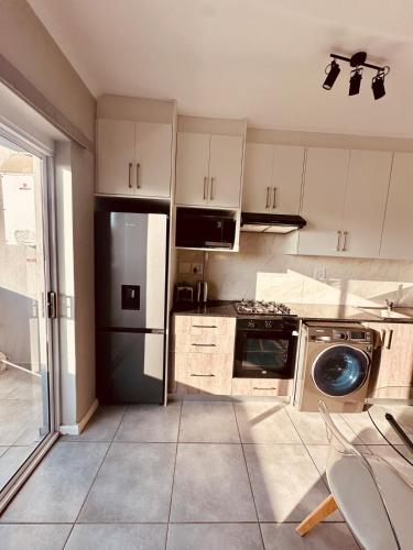 a kitchen with a black refrigerator and a dishwasher at Table Mountain View Apartment II in Cape Town