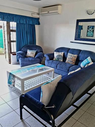 a living room with a blue couch and a coffee table at Happy Jack - Margate in Margate