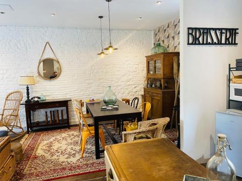 a living room with a table and a dining room at charming guest house in Bolbec