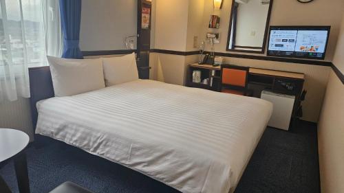 a hotel room with a bed and a desk at Toyoko Inn Tokyo Akigawa-eki Kita-guchi in Akiruno