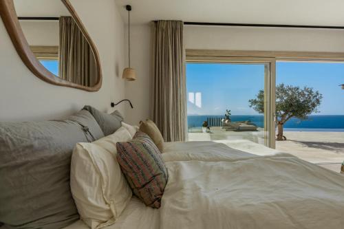 a bedroom with a bed with a view of the ocean at Villa Noema in Agiassos