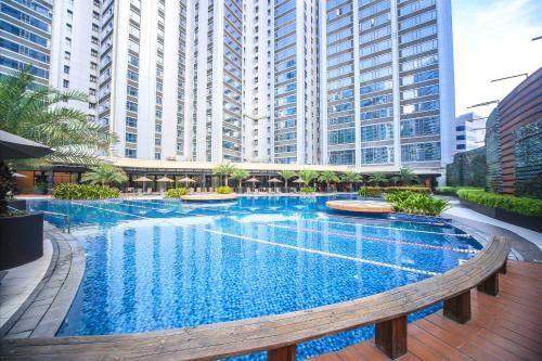 a large swimming pool in a city with tall buildings at The Alpha Suites in Manila
