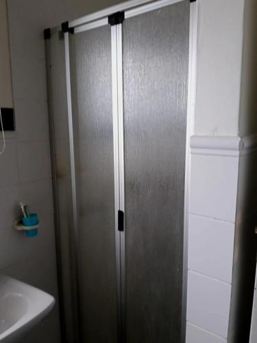 a metal shower door in a bathroom next to a sink at Happy Jack - Margate in Margate