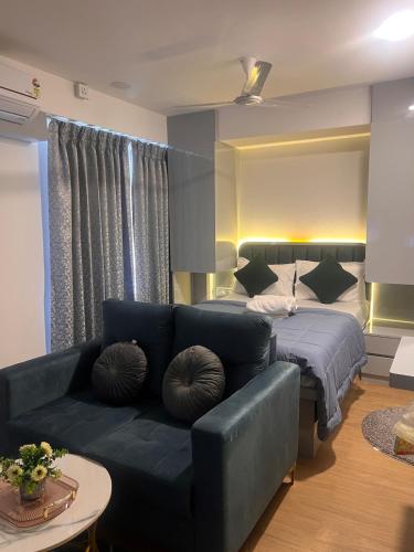a living room with a couch and a bed at NEON - Nirvana Stays With PVT Balcony -1 Km from Airport in Pune