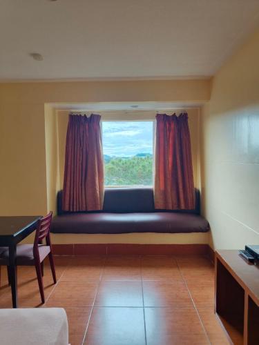 a room with a window with a couch and a table at Albergo Hotel in Baguio